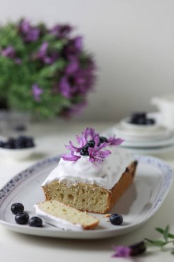 Taze yaban mersini meyveleri ve lavanta çiçekleriyle süslenmiş bir demet kek. Boşluğu kopyala