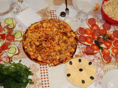 Yılbaşı arifesinde kaplanmış sofralar servis edilir. Pizza, peynir, Olivier salatası, zeytin ve Noel tatili. Rusya 'da yeni yıl yemeği dekorasyonu. Duvar kağıdı afişi..