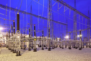 Alacakaranlıkta aydınlatılmış elektrik santrali.