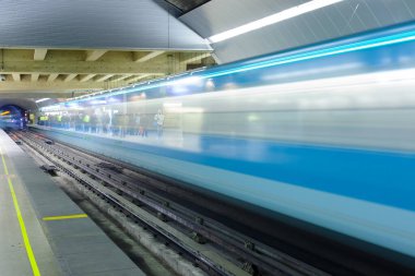 Santiago, Region Metropolitana, Chile - Motion blur of a subway train at Metro de Santiago with people waiting in the platform.