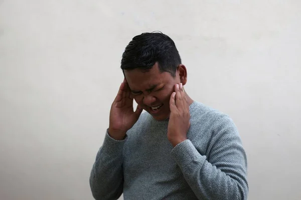 Seorang Pria Asia Mengenakan Sweater Memegang Kepalanya Dan Melihat Kesakitan — Stok Foto