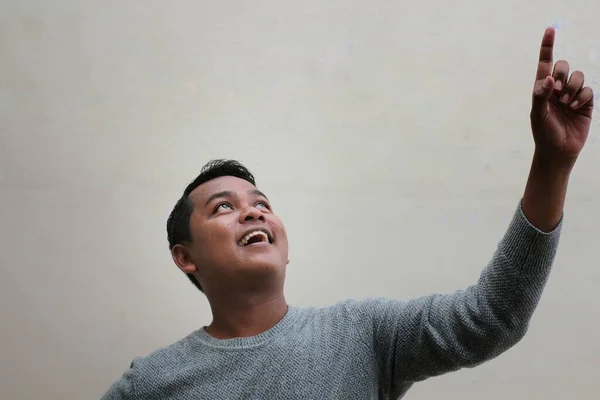 Seorang Pria Asia Mengenakan Sweater Mendongak Dan Menunjuk Sesuatu Atas — Stok Foto