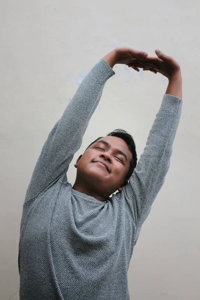 Asian Man Wearing Sweater Doing Stretching Movements Raising Both Hands — стоковое фото