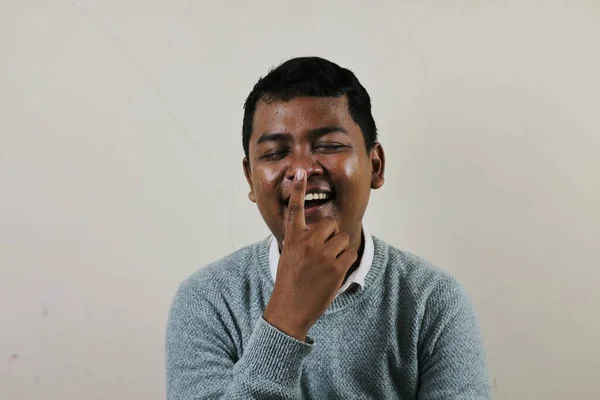 Seorang Pemuda Asia Tertawa Sambil Memegang Hidungnya Dengan Jari Telunjuknya — Stok Foto