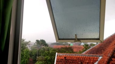 En üst kattaki binanın camlarına yağmur damlaları yağıyor.