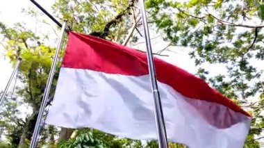 Indonesia's national flag with red and white colors fluttering in the wind during the day