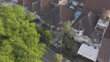 Sabahları Malang şehir manzarası, güneş çok katlı bir binanın tepesinden doğarken Malang şehir manzarası, sabahları sisli bir şehir.