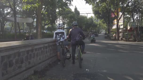 2022年6月23日インドネシア マラン 2人の自転車が休憩し ボトルから水を飲んでおしゃべりする — ストック動画