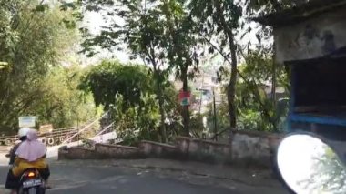 Malang, Endonezya -1 Temmuz 2022: Brantas Nehri üzerindeki asma köprüyü motosikletle geçmek