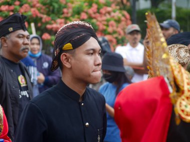Malang, Indonesia -11 September, 2022: carnival participants wear Javanese traditional clothes with blangkon