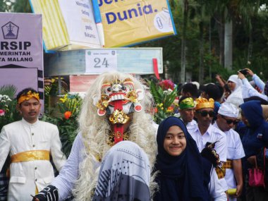 Malang, Indonesia -11 september, 2022 : spectators take pictures with carnival participants wearing Balinese leak masks, august carnival in malang city