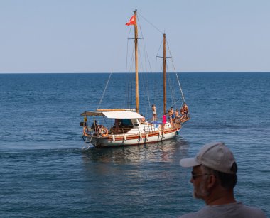 Ufuk ve adamın kafasının arka plan üzerinde siyah denizde bir dinlenme sahip yat
