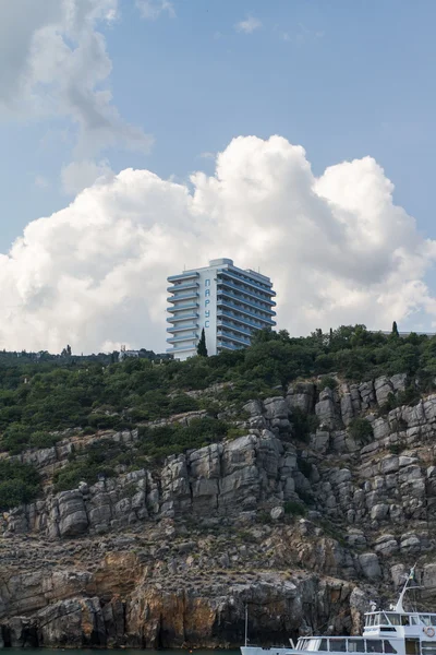 Otel "yelken" bulutlar, Kırım, Ukrayna bir arka plan üzerinde bir kayada duran, — Stok fotoğraf