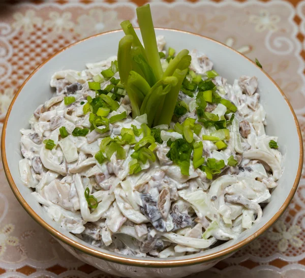 Ensalada de calamares con champiñones, adornada con cebollas verdes picadas Imagen De Stock