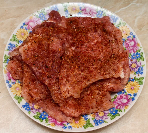 Picar cerdo con especias en un plato Imagen de archivo