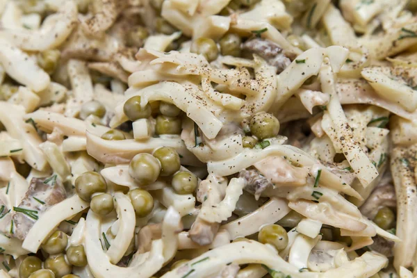 Салат из кальмаров с грибами и зеленым горохом — стоковое фото