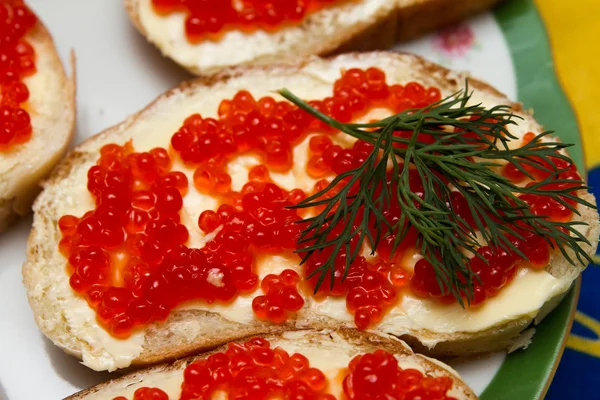 Sanduíches com caviar vermelho adornado com folhas de endro — Fotografia de Stock