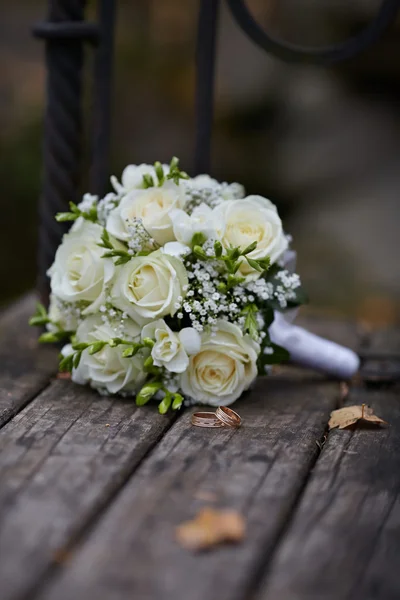 Anillos de boda y ramo de rosas blancas — Foto de Stock