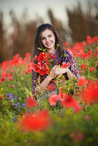 Vacker kaukasiska flicka i röd blomma fältet — Stockfoto