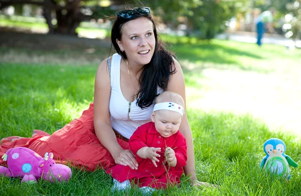 Mère avec le bébé sont joués sur la pelouse verte — Photo