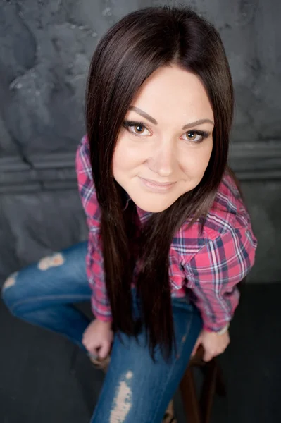 Young woman sitting on chair in interior. — Stock Photo, Image