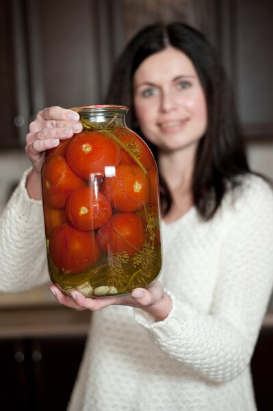 The woman preserves tomatoes