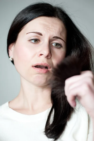 Fille regarde les pointes des cheveux — Photo