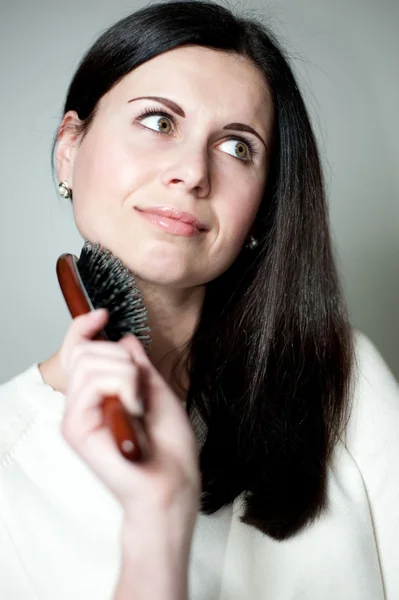 Žena česání její dlouhé vlasy — Stock fotografie