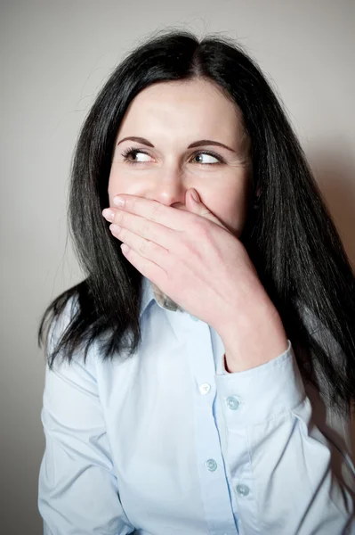 Woman smiles, covers a mouth with a palm — Stock Photo, Image