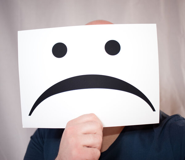 держа в руках бланковую бумагу с печальным лицом
