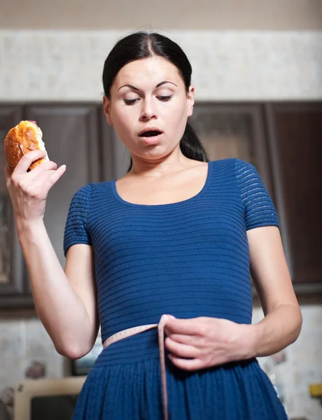 Young woman holds pie and a measuring tape — Stock Photo, Image