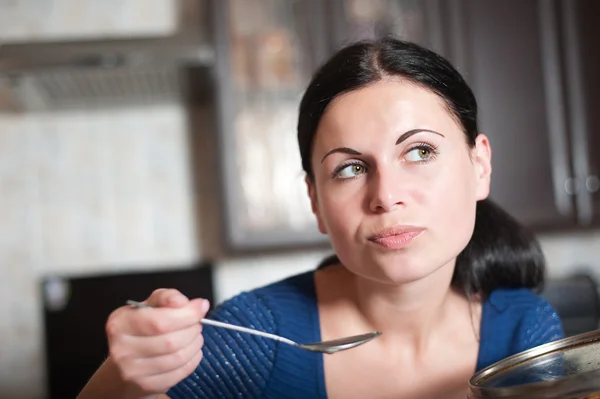 Jeune femme au foyer cuisine la nourriture dans la cuisine — Photo