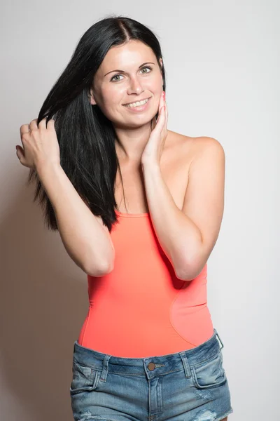 Mujer joven sonrisas encantadoras —  Fotos de Stock