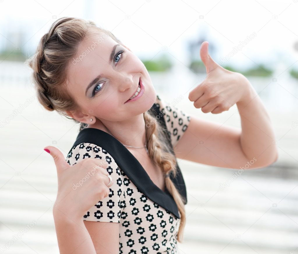Cheerful woman showing thumbs up