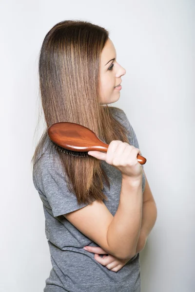 Young brunette beautiful lady combing long hairs — Stock Photo, Image