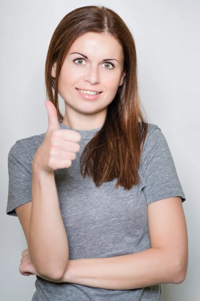 Jonge, mooie vrouw toont een duim — Stockfoto