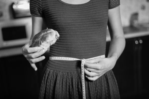 Jovem mulher segura torta e uma fita métrica — Fotografia de Stock