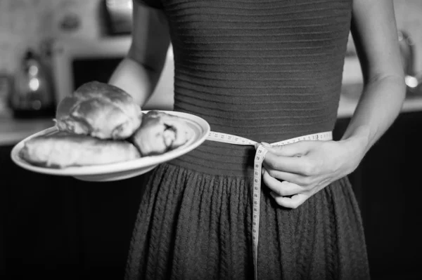 Молодая женщина держит пирог и измерительную ленту — стоковое фото