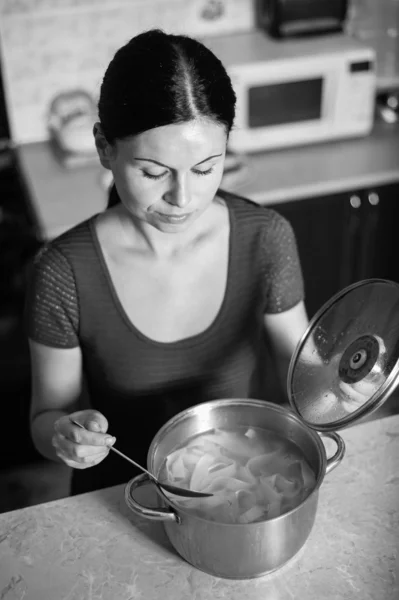 Joven ama de casa cocina comida en la cocina — Foto de Stock