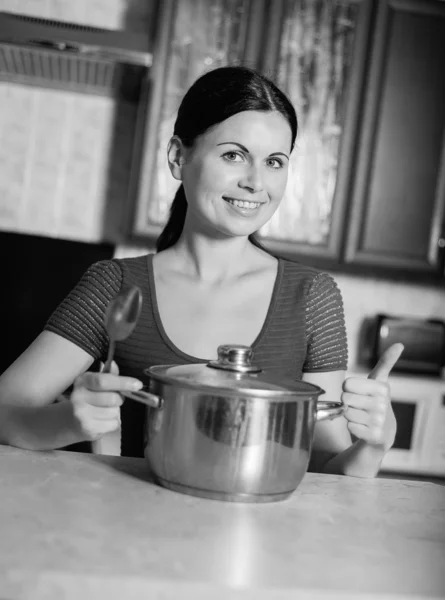 Junge Hausfrau kocht Essen in Küche — Stockfoto