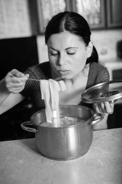 Joven ama de casa cocina comida en la cocina —  Fotos de Stock