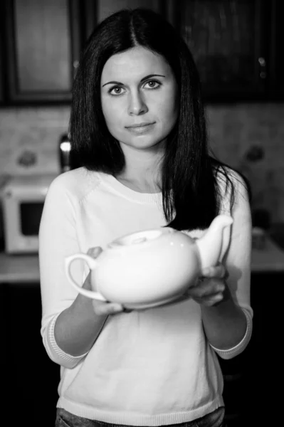 Young woman holds a teapot — 스톡 사진