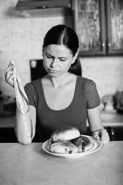 Jovem mulher segura torta e uma fita métrica — Fotografia de Stock