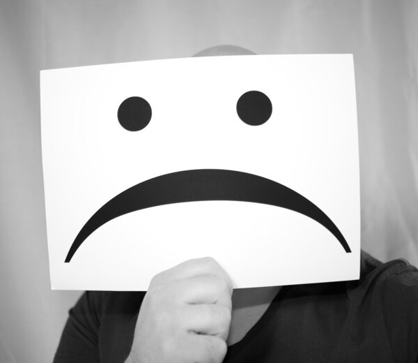 держа в руках бланковую бумагу с печальным лицом
