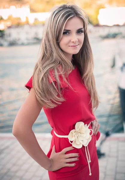 Mooi, jonge meisje, rode jurk, ziet er in de camera — Stockfoto