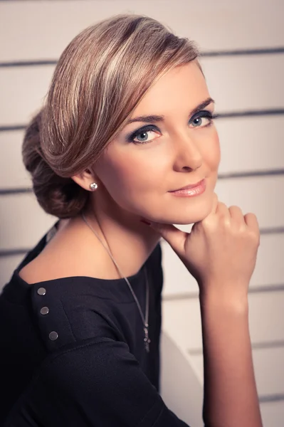 Young beautiful woman poses sitting, holds a hand near the pers — Stock Photo, Image