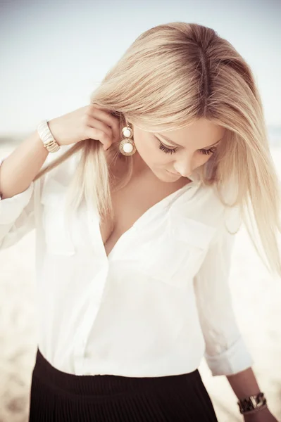 Junge schöne Blondine posiert am Strand — Stockfoto