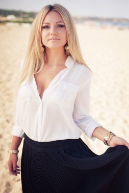 genç güzel kadın bir plajda sarışın pozlar