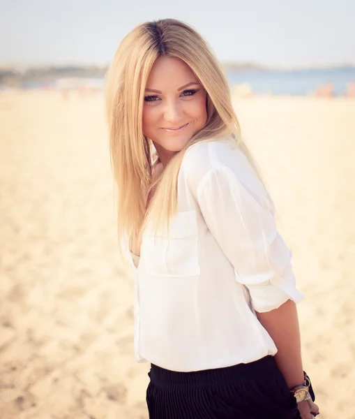 Young beautiful woman blonde poses on a beach — Stock Photo, Image