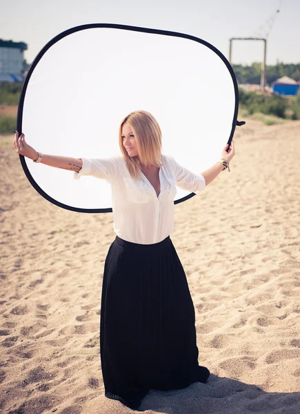 Jonge mooie vrouw blonde houdingen op een strand — Stockfoto